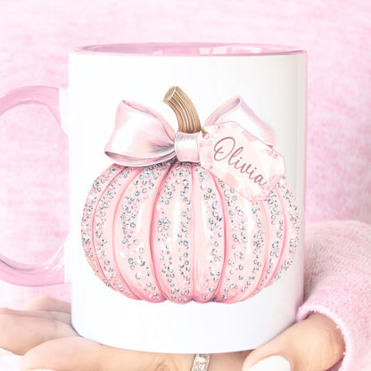 Pink pumpkin-shaped mug with a bow and 'Olivia' text on a pink background