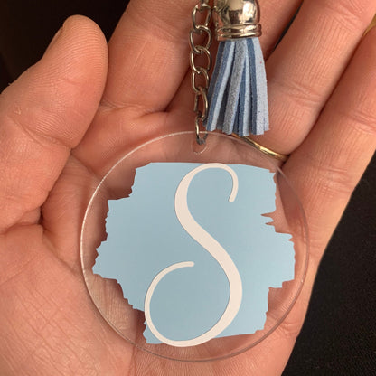 Keychain with a blue 'S' design held in a hand